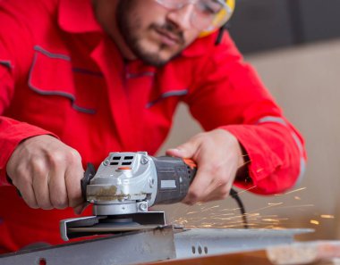 Öğütücü tekerlekle çalışan genç bir tamirci