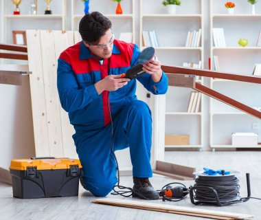 Genç marangoz ahşap kalaslarla çalışıyor.