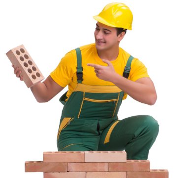 Yakışıklı inşaat işçisi tuğla duvar inşa ediyor.