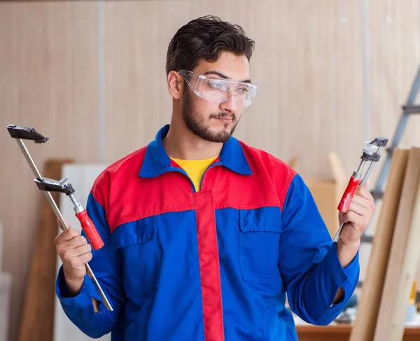 Junger Schreiner arbeitet mit Schellen — Stockfoto