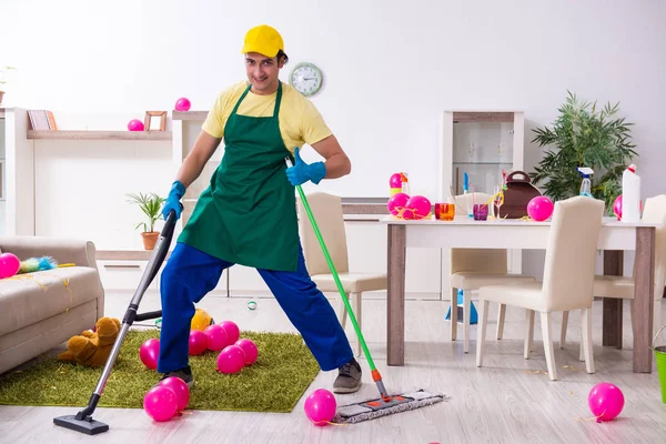 Jonge mannelijke aannemer doet huishoudelijk werk na partij — Stockfoto