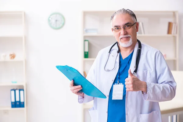 Gammal manlig läkare som arbetar på kliniken — Stockfoto