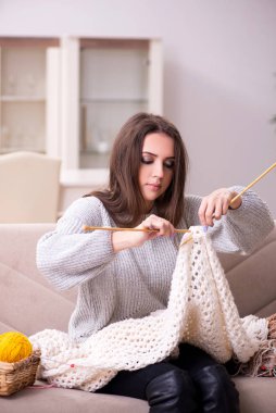 Evde örgü ören güzel bir kadın.