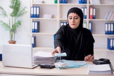 Ofiste çalışan tesettürlü kadın muhasebeci.