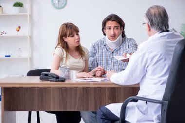 Genç çift yaşlı erkek doktoru ziyaret ediyor.