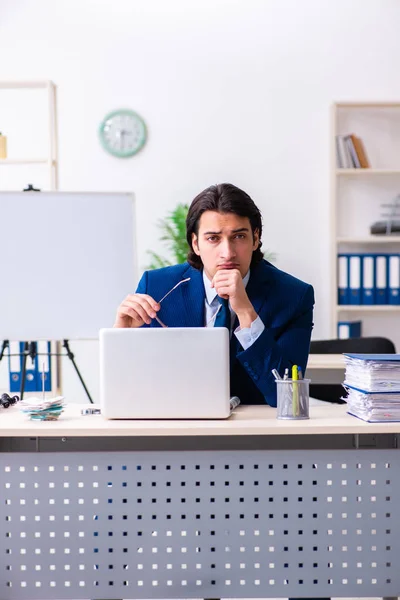 Молодой бизнесмен, сидящий и работающий в офисе — стоковое фото