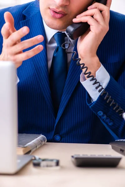 Jeune homme d'affaires assis et travaillant dans le bureau — Photo