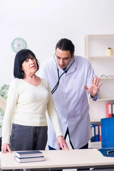 Jeune médecin examinant la vieille femme âgée — Photo