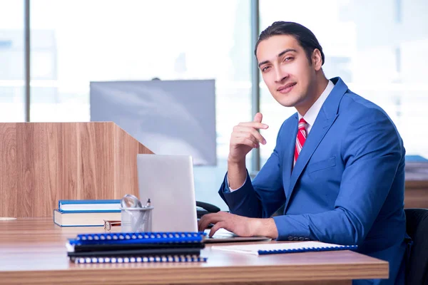 Jovem empresário bonito sentado no escritório — Fotografia de Stock