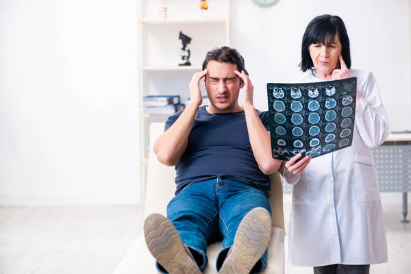 Young male patient visiting aged female doctor — Stock Photo, Image