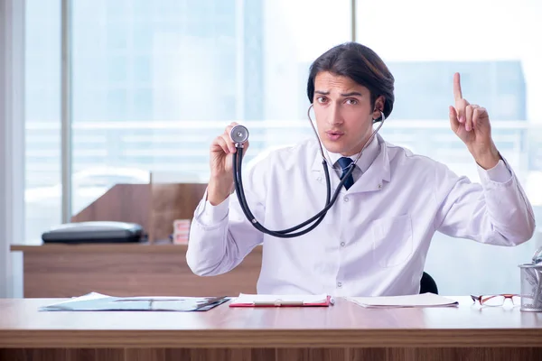 Giovane bel dottore che lavora in clinica — Foto Stock