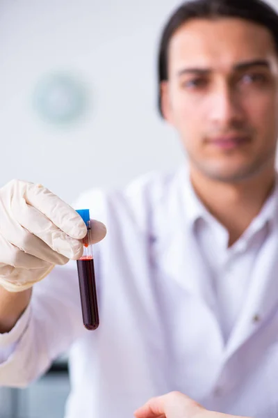 Asistente de laboratorio joven analizando muestras de sangre en el hospital — Foto de Stock