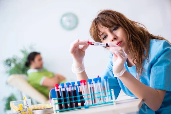 Asistente de laboratorio joven analizando muestras de sangre en el hospital —  Fotos de Stock