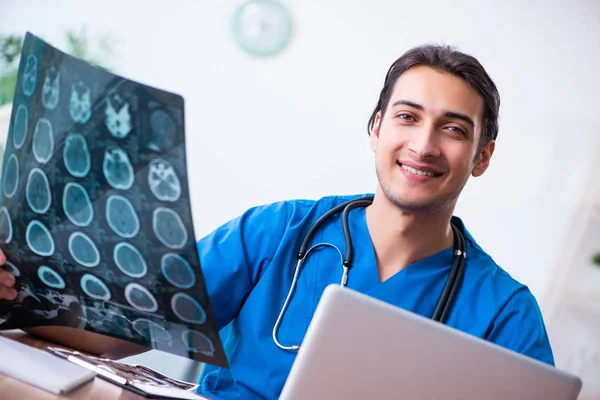 Ung manlig läkare tittar på röntgenbilder — Stockfoto
