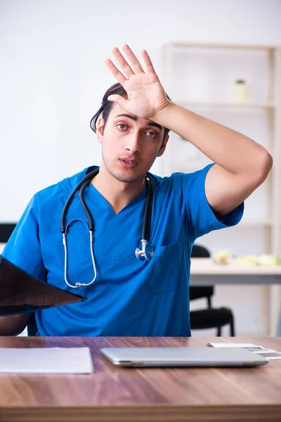 Joven médico masculino mirando imágenes de rayos X — Foto de Stock