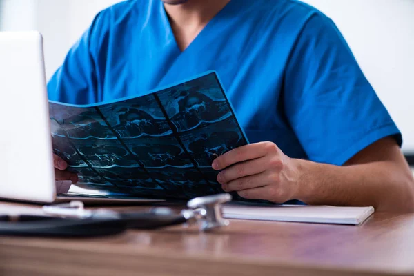 Joven médico masculino mirando imágenes de rayos X —  Fotos de Stock