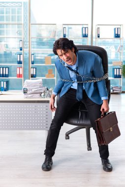 Zincirli erkek çalışan, aşırı çalışmaktan memnun değil.