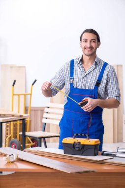 Genç erkek marangoz içeride çalışıyor.