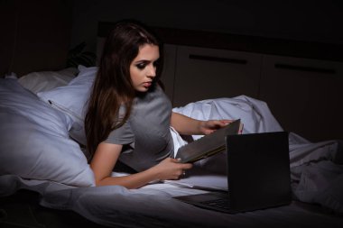 Yorgun iş kadını gece fazla mesai yapıyor.