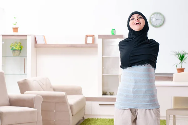 Ung kvinna i hijab gör övningar hemma — Stockfoto