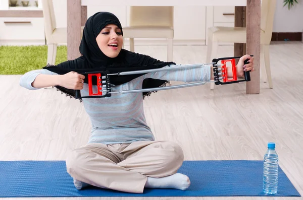 Junge Frau im Hidschab macht Übungen zu Hause — Stockfoto