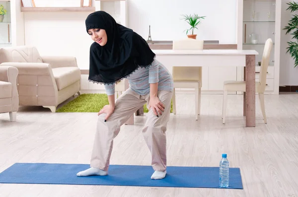 Junge Frau im Hidschab macht Übungen zu Hause — Stockfoto