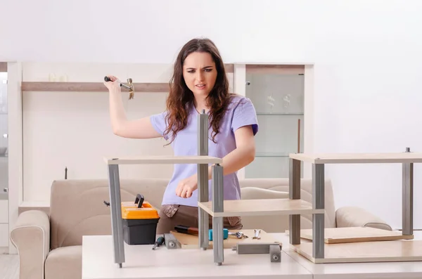 Ung kvinna reparera stol hemma — Stockfoto