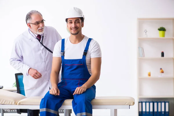 Genç erkek müteahhit yaşlı doktoru ziyaret ediyor. — Stok fotoğraf