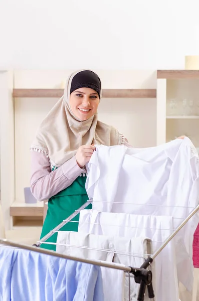 Vrouw in hijab doet kleding strijken thuis — Stockfoto