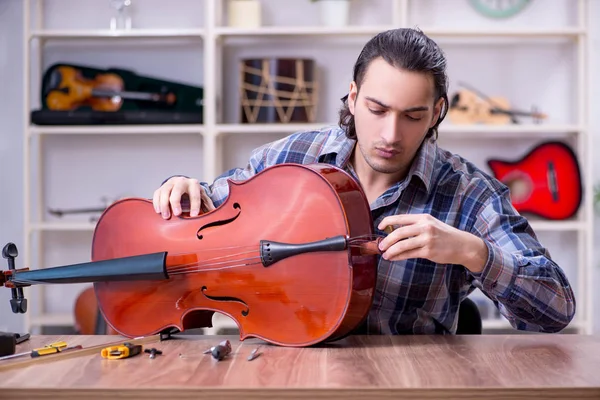 Jovem reparador bonito reparando violino — Fotografia de Stock