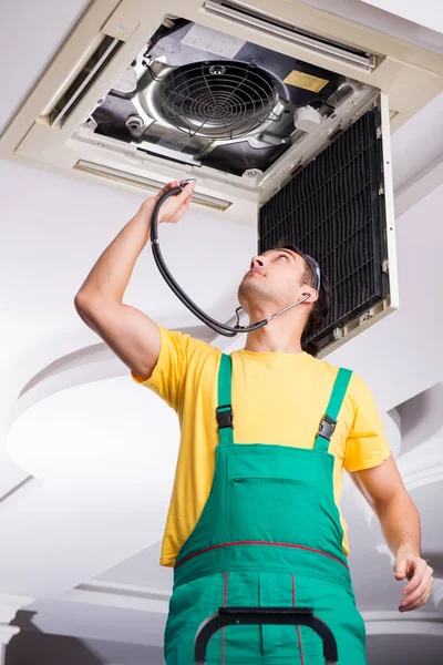 Young repairman repairing ceiling air conditioning unit — Stock Photo, Image