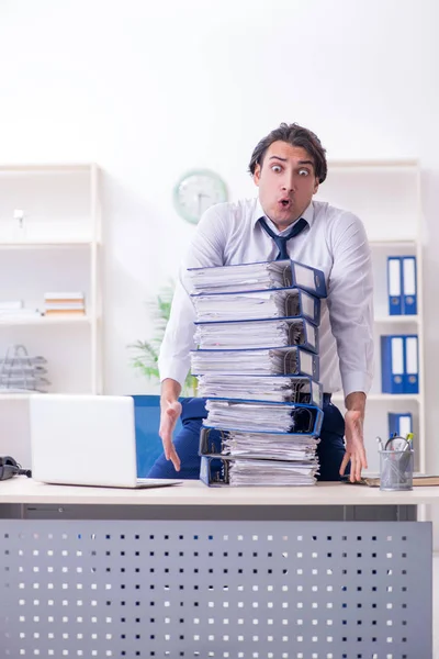 Joven empleado masculino infeliz con el trabajo excesivo —  Fotos de Stock