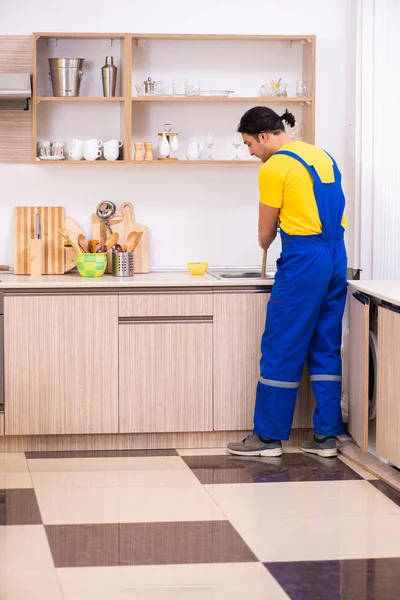 Jovem empreiteiro masculino reparando torneira em casa — Fotografia de Stock