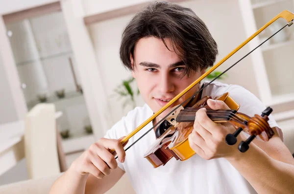 Mladý hudebník muž cvičí doma na housle — Stock fotografie