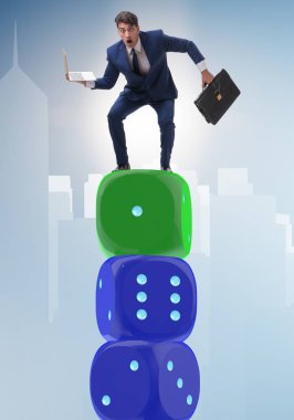 İş adamı belirsizlik içinde zar yığınının üzerinde dengede duruyor