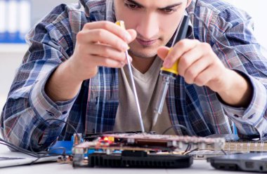 profesyonel tamirci atölyede bilgisayar tamir ediyor.