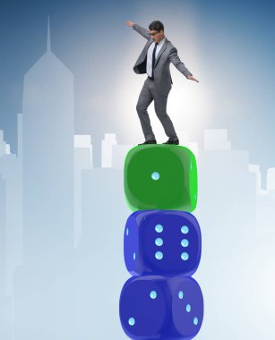 İş adamı belirsizlik içinde zar yığınının üzerinde dengede duruyor