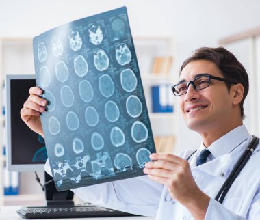 Doktor radyoloji uzmanı röntgen görüntülerine bakıyor.