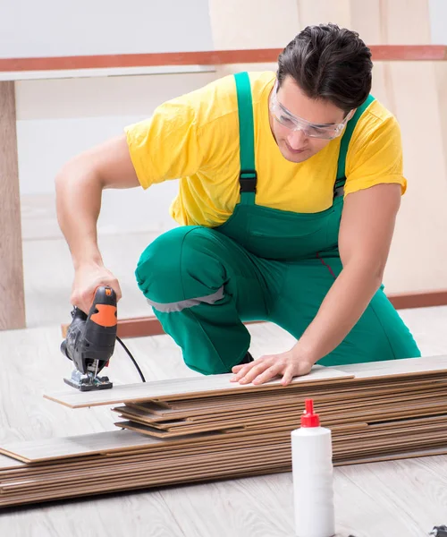 Contractor working on laminate wooden floor — Stock Photo, Image