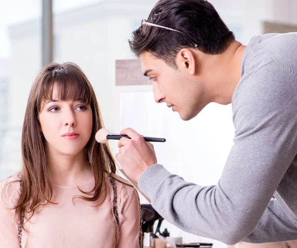 Hombre haciendo maquillaje para mujer linda en salón de belleza — Foto de Stock