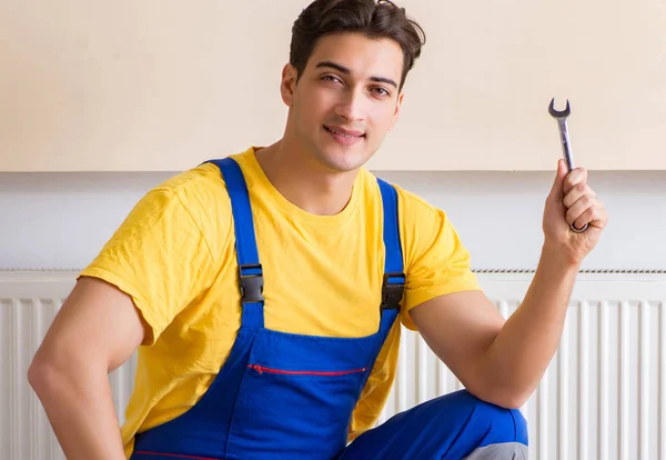 Jonge reparateur die verwarmingspaneel repareert — Stockfoto