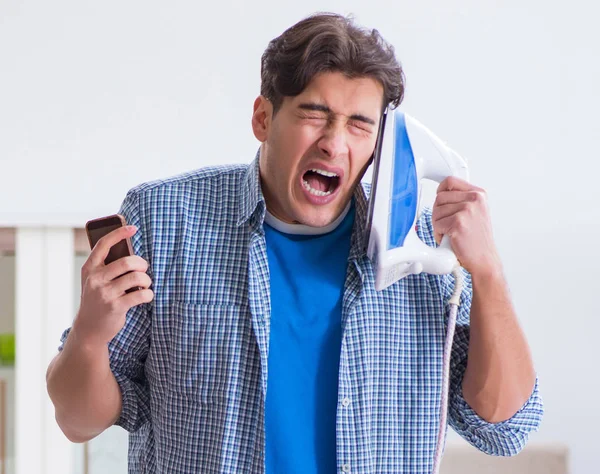 Joven marido haciendo planchado de ropa en casa — Foto de Stock