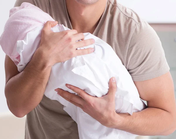 Jonge vader genieten van tijd met pasgeboren baby thuis — Stockfoto