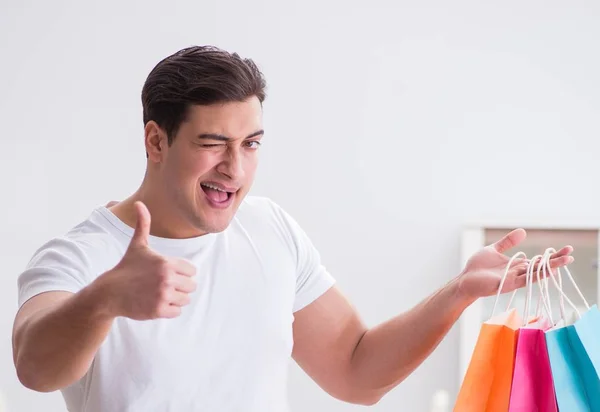 Jongeman met cadeau tas thuis voorbereiden verrassing voor vrouw — Stockfoto