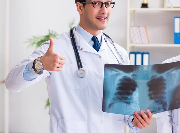 Two doctors examining x-ray images of patient for diagnosis — Stock Photo, Image