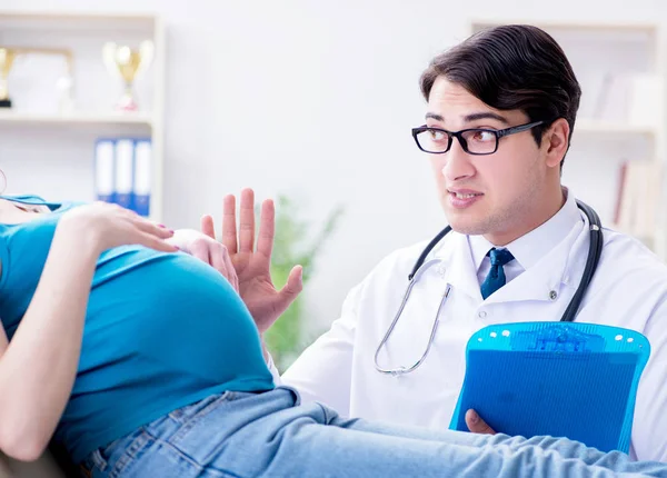 Läkare undersöka gravid kvinnlig patient på sjukhus — Stockfoto