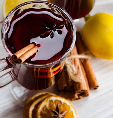 Haşlanmış şarap, yılbaşı masasında servis edilen bardaklarda parlıyor.