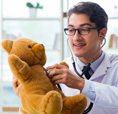 Ofiste oyuncaklı bir çocuk doktoru oturuyor.