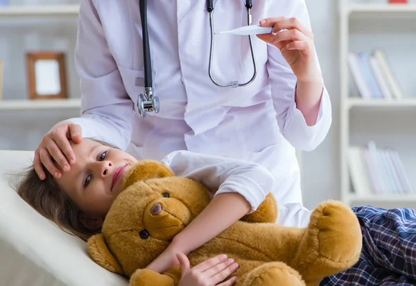 Vrouw vrouwelijke arts onderzoeken klein schattig meisje met speelgoed beer — Stockfoto