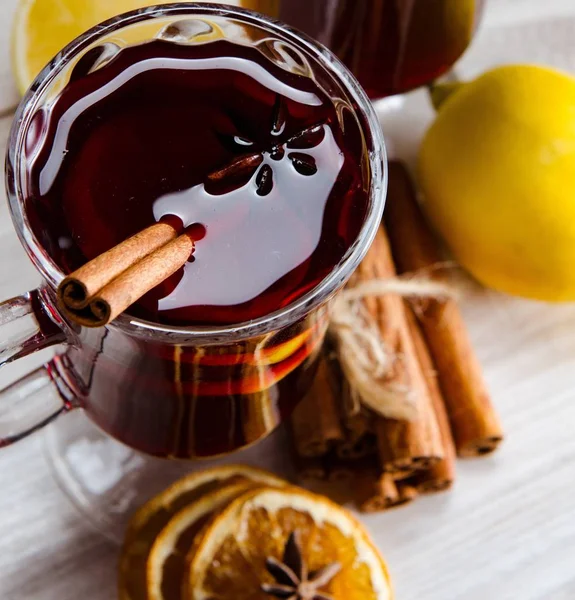 Haşlanmış şarap, yılbaşı masasında servis edilen bardaklarda parlıyor.